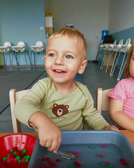 Uśmiechnięte dziecko podczas zabawy sensorycznej